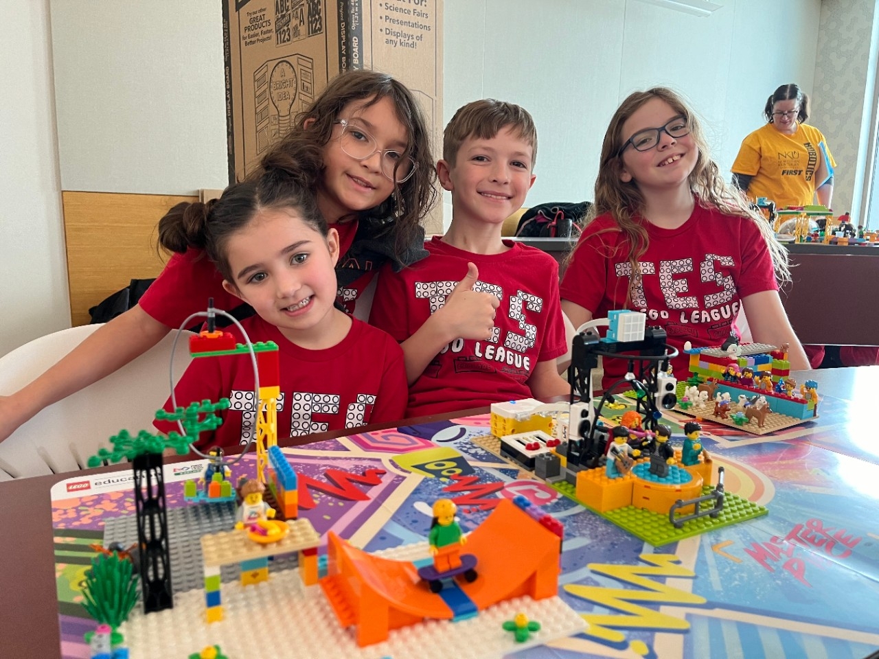 Kentucky FLL Explore Elementary-aged students smile for the camera with their team's colorful LEGO robotics creations at the annual FIRST LEGO League Explore Festival at Northern Kentucky University.