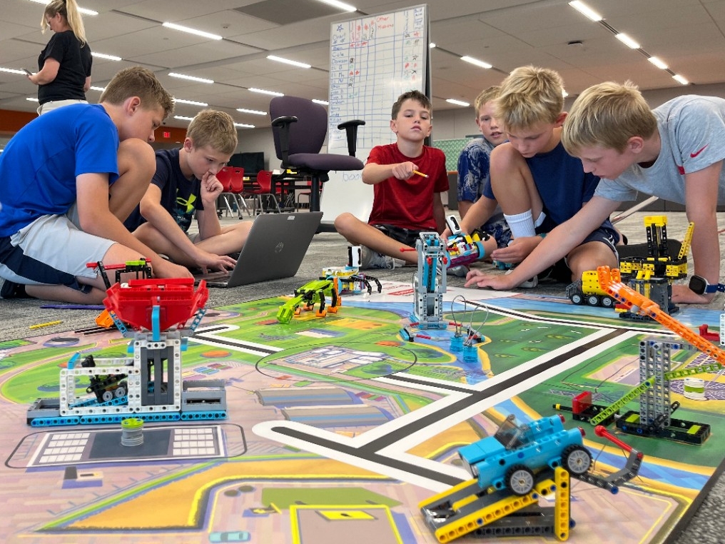 Spike Prime LEGO Robotics Camp Young kids using elementary programming software to build and code a moving LEGO robot