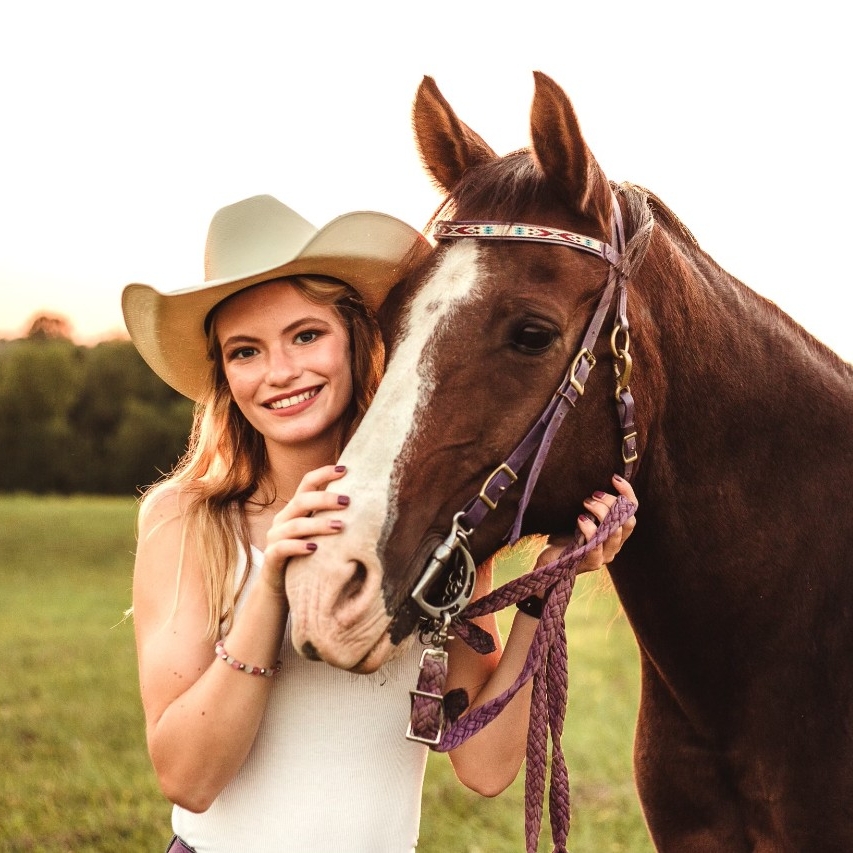 Alisha Detmer Alisha Detmer smiling standing next to her horse