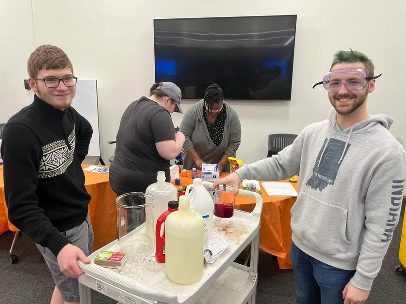 SAACS Club members smile as they prepare chemistry supplies for a demonstration.