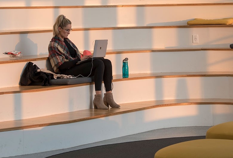 Student working on campus stairs