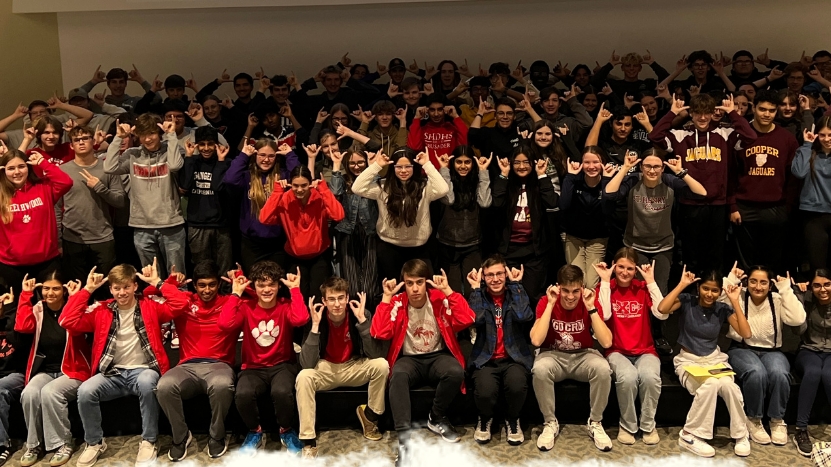 High school competitors give the "Norse Up" hand gesture for a large group picture.
