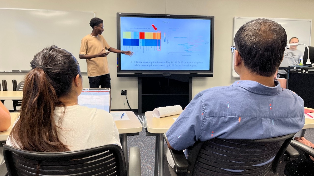 Department of Mathematics and Statistics at Northern Kentucky University NKU undergraduate student practices their research presentation to fellow members of the research team in a classroom setting.