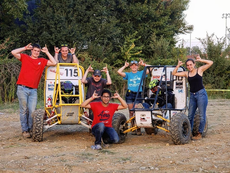 Norse Baja member do the Norse Up symbol for the camera near their racing carts
