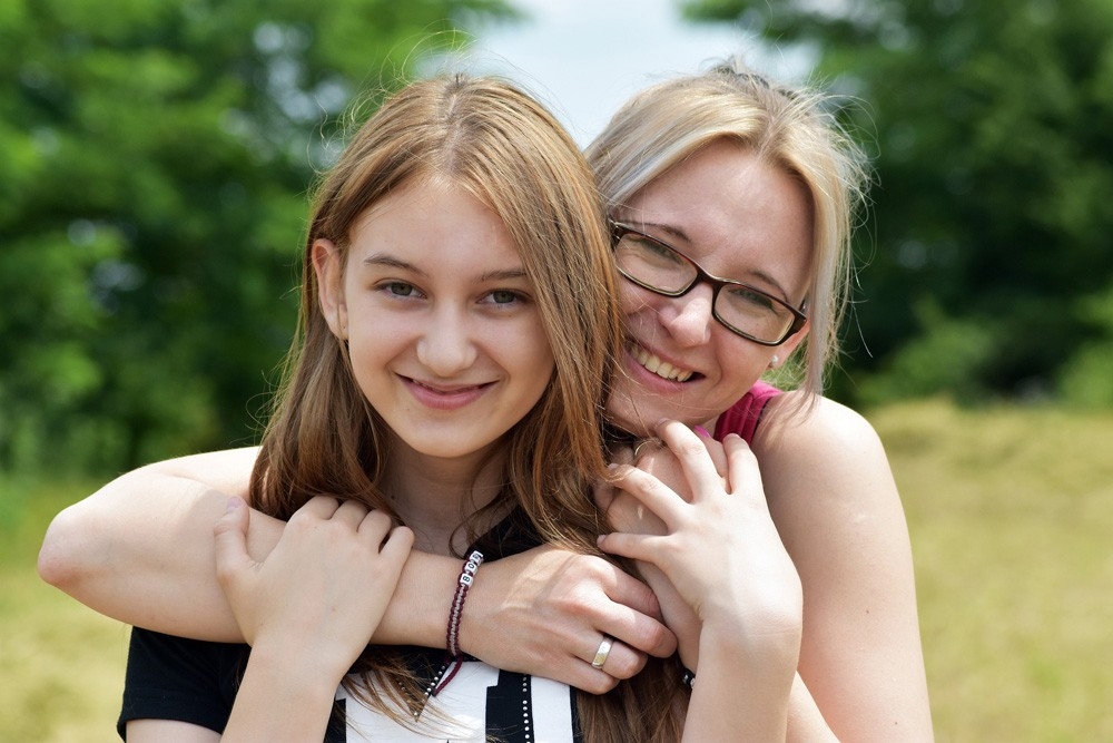 Mother and child hugging and looking at the camera