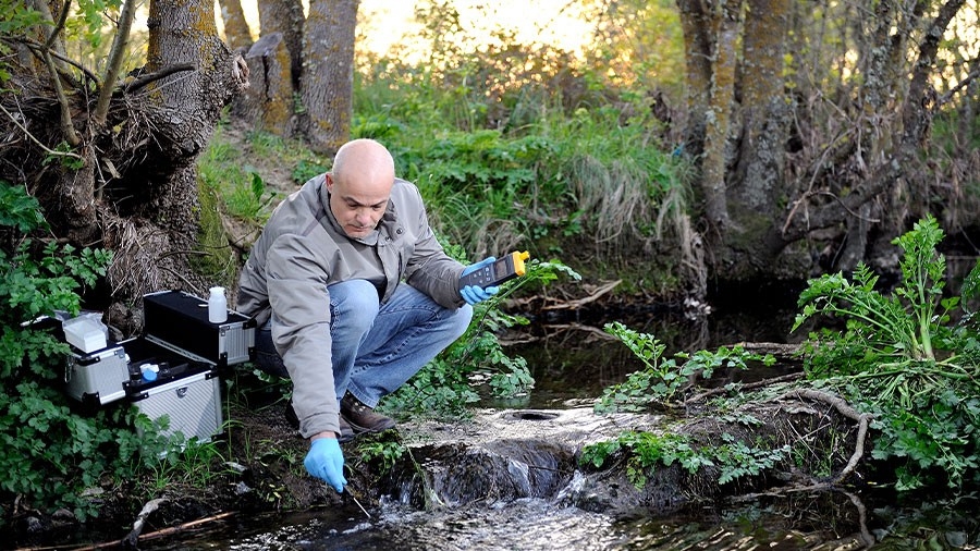 A technician tests the water flowing in a creek